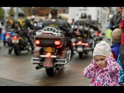 little girl holding ears at biker parade